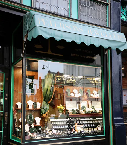 The Petersons Jewellers shop front on Hotel Street, Leicester, with its green awning and window display